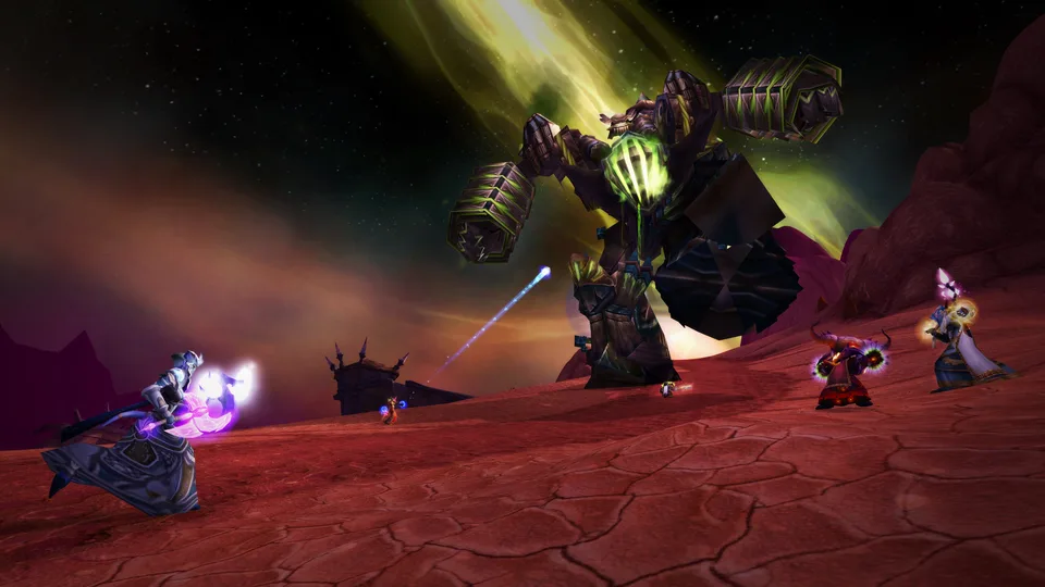 A group of players casts spells at a giant fel-powered colossus on the red cracked ground of Hellfire Peninsula under an aurora sky.